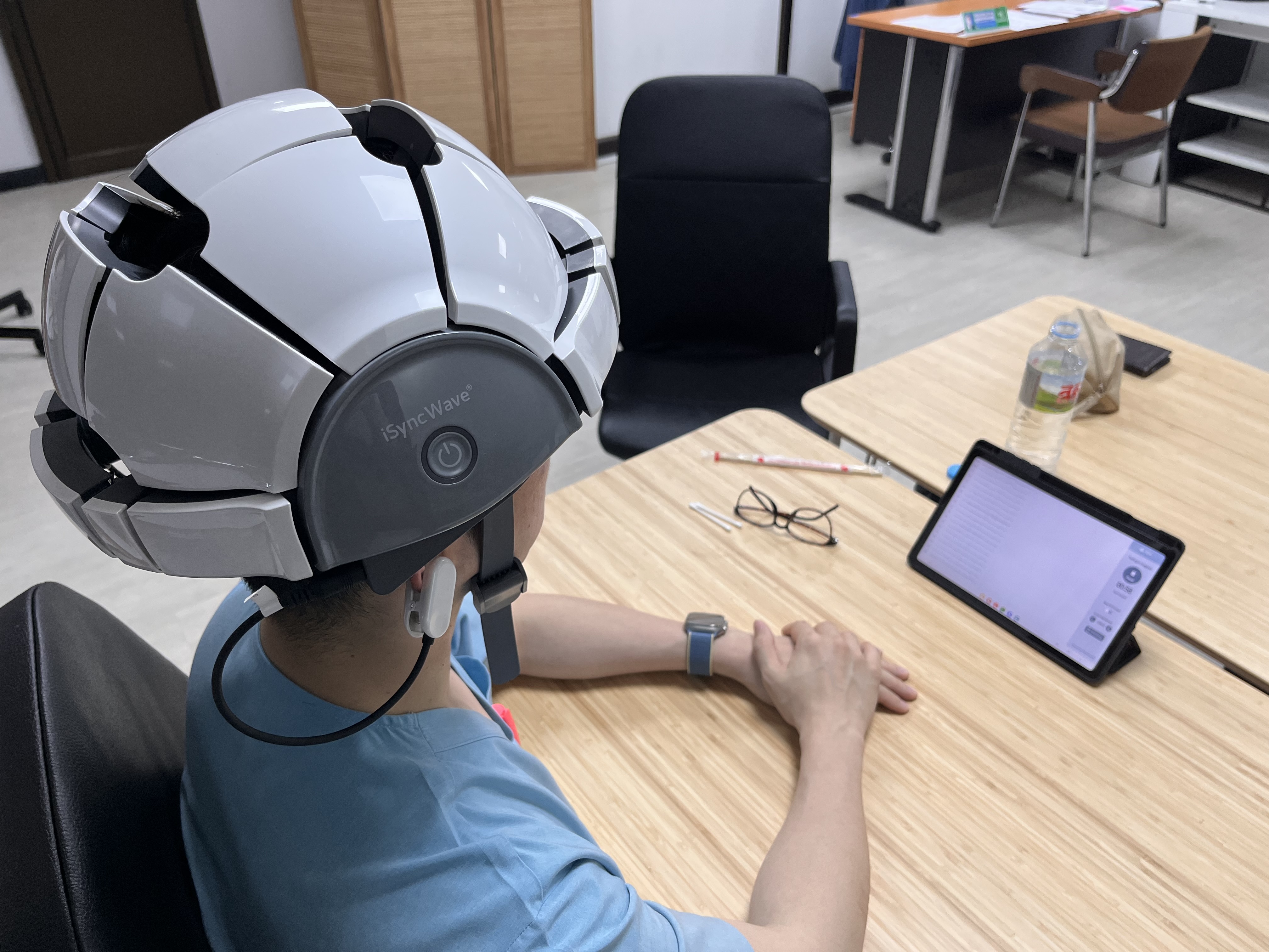 Patient wearing the iSyncWave dry-electrode EEG headset during a tablet-based session